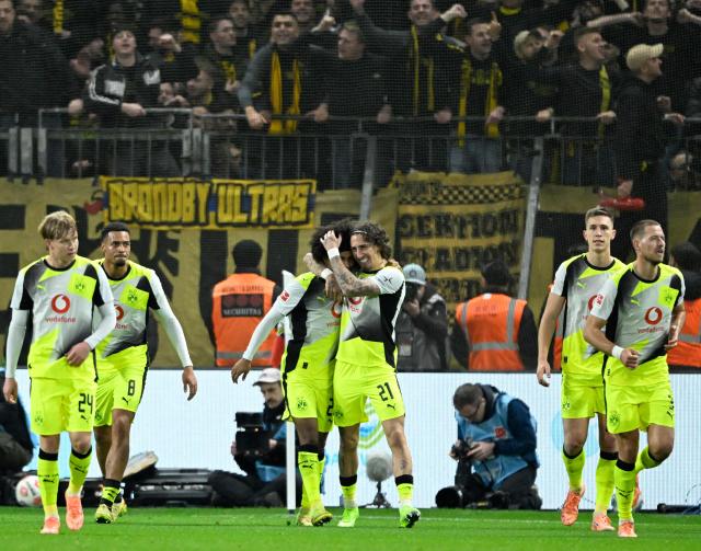 Dortmund's players celebrate the 0-2 during the German first division Bundesliga football match between Bayer 04 Leverkusen and Borussia Dortmund in Leverkusen, western Germany, on November 29, 2025. (Photo by INA FASSBENDER / AFP) / DFL REGULATIONS PROHIBIT ANY USE OF PHOTOGRAPHS AS IMAGE SEQUENCES AND/OR QUASI-VIDEO
