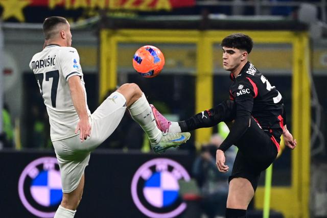 Lazio's Montenegrin defender #77 Adam Marusic (L) fights for the ball with AC Milan's Italian defender #33 Davide Bartesaghi (R) during the Italian Serie A football match between AC Milan and Lazio at the San Siro stadium in Milan on November 29, 2025. (Photo by Piero CRUCIATTI / AFP)