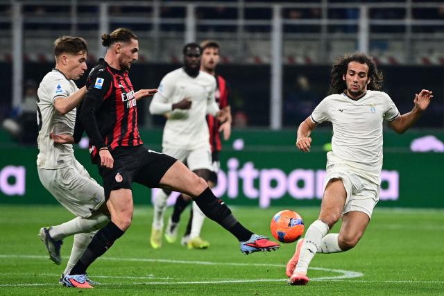 AC Milan's French midfielder #12 Adrien Rabiot (2ndL) fights for the ball with Lazio's Croatian midfielder #26 Toma Basic (L) and Lazio's French midfielder #08 Matteo Guendouzi (R) during the Italian Serie A football match between AC Milan and Lazio at the San Siro stadium in Milan on November 29, 2025. (Photo by Piero CRUCIATTI / AFP)