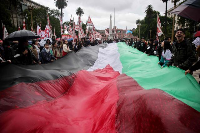 Demonstrators hold a large Palestinian flag during a pro-Palestinian march in Buenos Aires, on November 29, 2025. (Photo by Emiliano Lasalvia / AFP)
