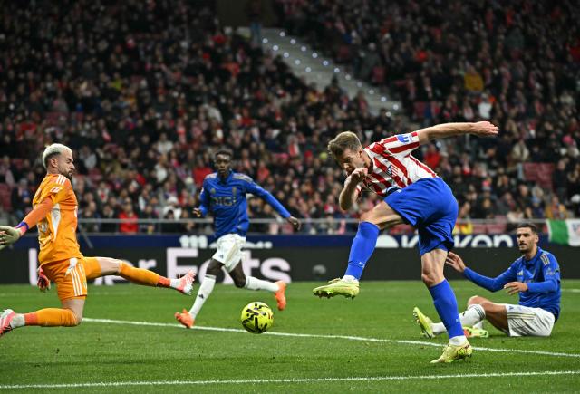 TOPSHOT - Atletico Madrid's Norwegian forward #09 Alexander Sorloth scores his team's second goal in spite of Real Oviedo's Spanish goalkeeper #13 Aaron Escandell Banacloche during the Spanish League football match between Club Atletico de Madrid and Real Oviedo at Metropolitano Stadium in Madrid on November 29, 2025. (Photo by Javier SORIANO / AFP)