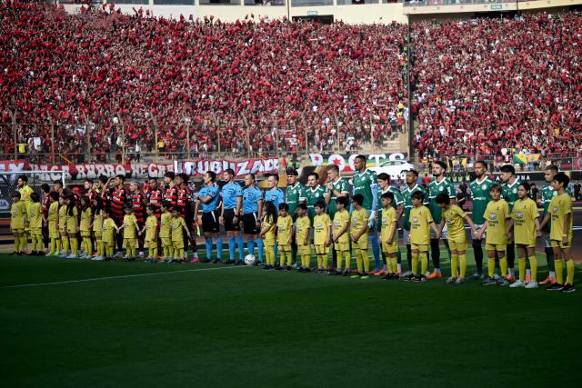 Players of Flamengo (L) and Palmeiras, along with referees, line up ahead of the all-Brazilian Copa Libertadores final between Palmeiras and Flamengo at Monumental “U” Marathon Stadium in Lima, Peru, on November 29, 2025. (Photo by ERNESTO BENAVIDES / AFP)