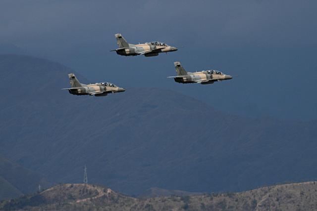 A squad of Venezuelan Air Force K8W aircraft overflies during the 2025 Venezuela industrial aviation expo at the Libertador Air Base in Maracay, Aragua State, Venezuela, on November 29, 2025. (Photo by Federico PARRA / AFP)
