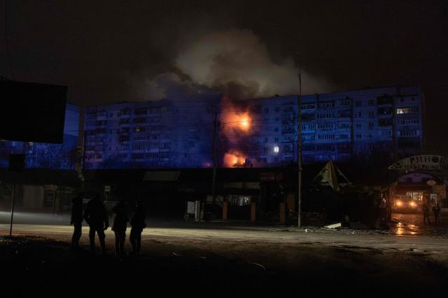 People look at a residential building on fire following a Russian drone attack on the city of Vyshhorod in the Kyiv region, early on November 30, 2025, amid the Russian invasion of Ukraine. (Photo by Roman PILIPEY / AFP)