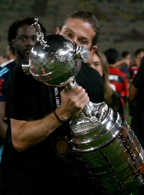 Flamengo's head coach Filipe Luis kisses the trophy after winning the all Brazilian Copa Libertadores final football match between Palmeiras and Flamengo at Monumental 'U' Marathon stadium in Lima on November 29, 2025. (Photo by Luis ACOSTA / AFP)
