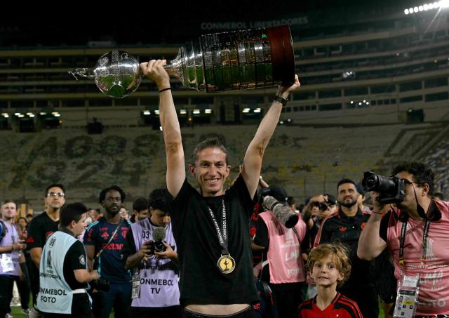 Flamengo's head coach Filipe Luis lifts the trophy after winning the all Brazilian Copa Libertadores final football match between Palmeiras and Flamengo at Monumental 'U' Marathon stadium in Lima on November 29, 2025. (Photo by Luis ACOSTA / AFP)