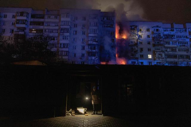 A person checks damages next to a residential building on fire following a Russian drone attack on the city of Vyshhorod, in the Kyiv region early on November 30, 2025, amid the Russian invasion of Ukraine. (Photo by Roman PILIPEY / AFP)