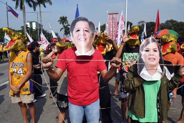 Protesters wearing face masks depicting Philippine President Ferdinand Marcos (C) and Vice President Sara Duterte (R) take part in an anti-corruption rally near a park on Manila on November 30, 2025. (Photo by TED ALJIBE / AFP)