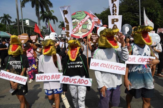 Protesters wearing crocodile masks march during an anti-corruption rally near a park on Manila on November 30, 2025. (Photo by TED ALJIBE / AFP)
