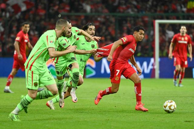 Toluca's forward #07 Juan Dominguez runs with the ball past Juarez's Brazilian midfielder #08 Guilherme Castilho during the Liga MX Apertura quarter-final second leg football match between Toluca and Juarez, at Nemesio Diez stadium in Toluca de Lerdo, state of Mexico, Mexico on November 29, 2025. (Photo by Mario Vazquez / AFP)