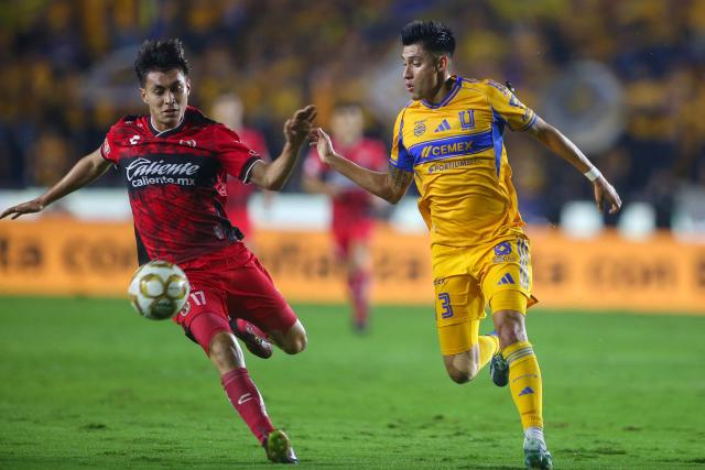 Tijuana's forward #17 Ramiro Arciga and Tigres' US defender #03 Marco Farfan fight for the ball during the Liga MX Apertura quarter-final second leg football match between Tigres and Tijuana at the UANL University Stadium in San Nicolas de los Garza, Nuevo Leon State, Mexico on November 29, 2025. (Photo by Julio Cesar AGUILAR / AFP)