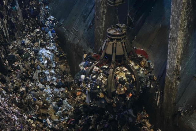 A photograph taken on November 25, 2025, shows a grapple taking mixed solid waste in a garbage pit to load the furnace at the Isseane Syctom incinerator of Issy-les-Moulineaux, in the outskirts of Paris. (Photo by Thomas SAMSON / AFP)