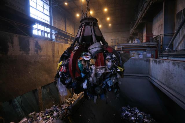 A photograph taken on November 25, 2025, shows a grapple taking mixed solid waste in a garbage pit to load the furnace at the Isseane Syctom incinerator of Issy-les-Moulineaux, in the outskirts of Paris. (Photo by Thomas SAMSON / AFP)