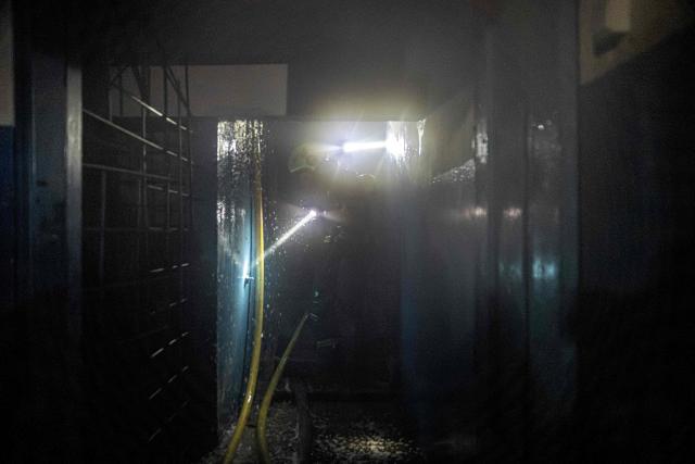 Firefighters prepare to douse a residential building set ablaze following a Russian drone attack on the city of Vyshhorod, in the Kyiv region early on November 30, 2025, amid the Russian invasion of Ukraine. A Russian drone attack has killed one person and wounded 11 on the outskirts of the Ukrainian capital, the regional governor said on November 30. (Photo by Roman PILIPEY / AFP)