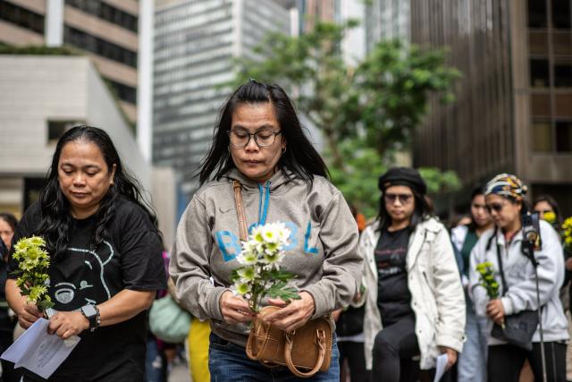 Philippine nationals in Hong Kong take part in a community prayer service for victims of the deadly November 26 fire at Tai Po, in Hong Kong’s Central district on November 30, 2025. An outpouring of grief swept Hong Kong on November 29, as thousands paid their respects and laid flowers for the 128 people killed in one of the city's deadliest fires, marking the start of an official three-day mourning period. (Photo by Philip FONG / AFP)