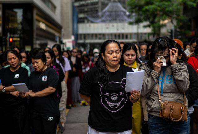 Philippine nationals in Hong Kong take part in a community prayer service for victims of the deadly November 26 fire at Tai Po, in Hong Kong’s Central district on November 30, 2025. An outpouring of grief swept Hong Kong on November 29, as thousands paid their respects and laid flowers for the 128 people killed in one of the city's deadliest fires, marking the start of an official three-day mourning period. (Photo by Philip FONG / AFP)