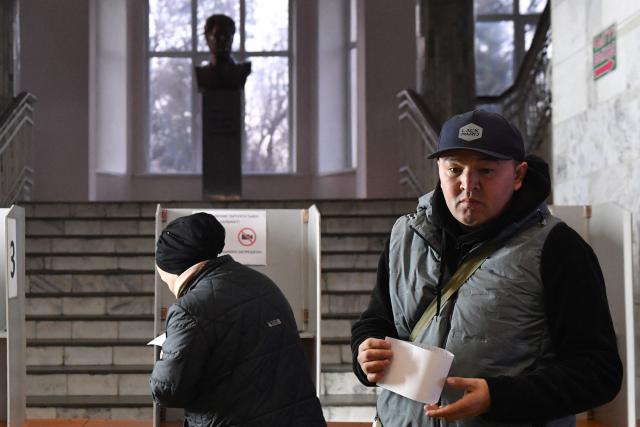 People vote at a polling station during Kyrgyzstan's snap parliamentary elections in Bishkek on November 30, 2025. (Photo by Vyacheslav OSELEDKO / AFP)