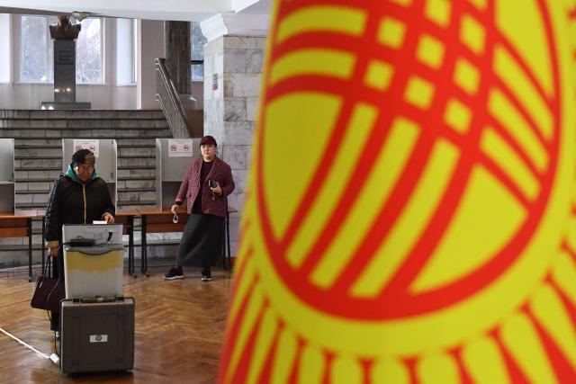 People vote at a polling station during Kyrgyzstan's snap parliamentary elections in Bishkek on November 30, 2025. (Photo by Vyacheslav OSELEDKO / AFP)