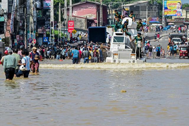Army personnel ride a military truck as they wade through a flooded road after heavy rainfall in Wellampitiya on the outskirts of Colombo on November 30, 2025. Sri Lankan authorities battled rising floodwaters in parts of the capital on November 30 after a powerful cyclone left a trail of destruction, killing at least 159 people across the country. (Photo by Ishara S. KODIKARA / AFP)