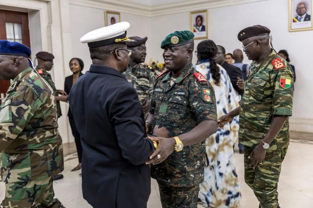 Brigadier General Denis N'Canha (C) congratulates newly appointed Minister of Health, Commodore Quinhin Nantote (CL), during the swearing-in ceremony of the newly formed government at the Presidential Palace in Bissau on November 29, 2025. Guinea-Bissau's junta formed a government on Saturday days after taking power in a coup, as ousted president Umaro Sissoco Embalo arrived in the Republic of Congo's capital Brazzaville. The military took control of the Portuguese-speaking nation on Wednesday -- a day before the provisional results of national elections were due to be announced -- and Embalo had initially left for neighbouring Senegal.
On Saturday the junta tapped 28 people, including five army officers and four women, to lead the drug-trafficking hotspot. (Photo by PATRICK MEINHARDT / AFP)