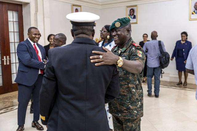 Brigadier General Denis N'Canha (C) congratulates newly appointed Minister of Health, Commodore Quinhin Nantote (CL), during the swearing-in ceremony of the newly formed government at the Presidential Palace in Bissau on November 29, 2025. Guinea-Bissau's junta formed a government on Saturday days after taking power in a coup, as ousted president Umaro Sissoco Embalo arrived in the Republic of Congo's capital Brazzaville. The military took control of the Portuguese-speaking nation on Wednesday -- a day before the provisional results of national elections were due to be announced -- and Embalo had initially left for neighbouring Senegal.
On Saturday the junta tapped 28 people, including five army officers and four women, to lead the drug-trafficking hotspot. (Photo by PATRICK MEINHARDT / AFP)