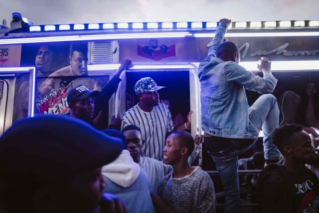 Fans gather around a matatu -Kenya’s iconic, privately owned public transport minibus- ahead of the 4th Nganya Awards in Nairobi on November 29, 2025. The Nganya Awards is a celebration of Kenya’s matatu culture, honoring the matatu scene and the unique lifestyle around them. This years awards had over 40 categories, from matatu crews to vehicle designers, sound system and social influencers linked to the matatu lifestyle, with voting taking place ahead of the award show. (Photo by Fredrik LERNERYD / AFP)