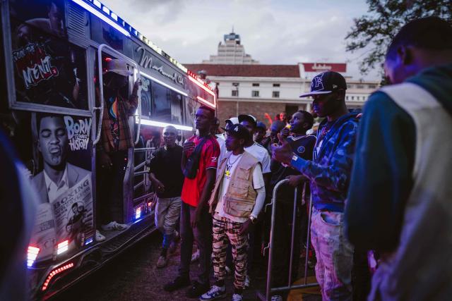 Fans gather around a matatu -Kenya’s iconic, privately owned public transport minibus- ahead of the 4th Nganya Awards in Nairobi on November 29, 2025. The Nganya Awards is a celebration of Kenya’s matatu culture, honoring the matatu scene and the unique lifestyle around them. This years awards had over 40 categories, from matatu crews to vehicle designers, sound system and social influencers linked to the matatu lifestyle, with voting taking place ahead of the award show. (Photo by Fredrik LERNERYD / AFP)