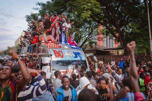 A group of fans arrives atop a matatu -Kenya’s iconic, privately owned public transport minibus- for the 4th Nganya Awards in Nairobi on November 29, 2025. The Nganya Awards is a celebration of Kenya’s matatu culture, honoring the matatu scene and the unique lifestyle around them. This years awards had over 40 categories, from matatu crews to vehicle designers, sound system and social influencers linked to the matatu lifestyle, with voting taking place ahead of the award show. (Photo by Fredrik LERNERYD / AFP)