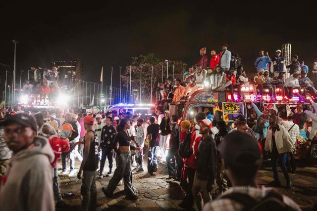 A group of fans rides atop a matatu -Kenya’s iconic, privately owned public transport minibus- driving around the venue as fans gather for the 4th Nganya Awards in Nairobi on November 29, 2025. The Nganya Awards is a celebration of Kenya’s matatu culture, honoring the matatu scene and the unique lifestyle around them. This years awards had over 40 categories, from matatu crews to vehicle designers, sound system and social influencers linked to the matatu lifestyle, with voting taking place ahead of the award show. (Photo by Fredrik LERNERYD / AFP)