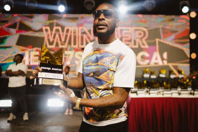 A member of the organizing team holds an award trophy for the 4th Nganya Awards celebrating matatu culture -Kenya’s iconic, privately owned public transport minibus- on stage in Nairobi on November 29, 2025. The Nganya Awards is a celebration of Kenya’s matatu culture, honoring the matatu scene and the unique lifestyle around them. This years awards had over 40 categories, from matatu crews to vehicle designers, sound system and social influencers linked to the matatu lifestyle, with voting taking place ahead of the award show. (Photo by Fredrik LERNERYD / AFP)