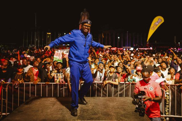 An MC in a Kenya Police uniform dances on stage as fans gather for the 4th Nganya Awards celebrating matatu culture -Kenya’s iconic, privately owned public transport minibus- in Nairobi on November 29, 2025. The Nganya Awards is a celebration of Kenya’s matatu culture, honoring the matatu scene and the unique lifestyle around them. This years awards had over 40 categories, from matatu crews to vehicle designers, sound system and social influencers linked to the matatu lifestyle, with voting taking place ahead of the award show. (Photo by Fredrik LERNERYD / AFP)
