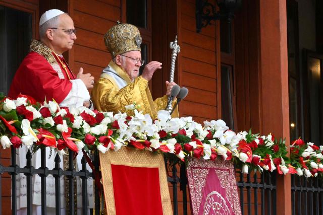 Pope Leo XIV and Patriarch Bartholomew I bless the crowd from the balcony of the patriarchate following a Divine Liturgy at Patriarchal Church of Saint George, in Istanbul on November 30, 2025. (Photo by Andreas SOLARO / AFP)