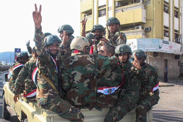 Yemeni armed forces flash the V-sign for victory as they ride in the back of a lorry as the Southern Armed Forces Command celebrate the 58th anniversary of National Independence Day, in the port city of Aden, in the southern part of the Arabian peninsula on November 30, 2025. Yemen's National Independence Day commemorates the establishment of the People’s Republic of South Yemen after more than 120 years of British presence centred around the port of Aden. (Photo by Saleh Al-OBEIDI / AFP)