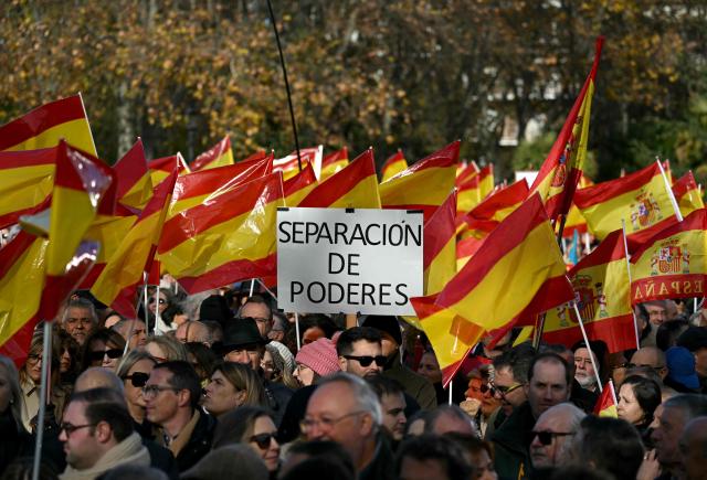 Protestors hold Spain's flags and a banner reading 'Separation of powers' during a demonstration against corruption called by the right-wing opposition party Partido Popular (PP) in front of Debod Temple in Madrid on November 30, 2025. (Photo by Javier SORIANO / AFP)