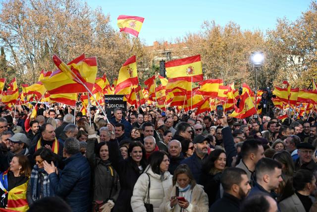 Protestors hold Spain's flags during a demonstration against corruption called by the right-wing opposition party Partido Popular (PP) in front of Debod Temple in Madrid on November 30, 2025. (Photo by JAVIER SORIANO / AFP)