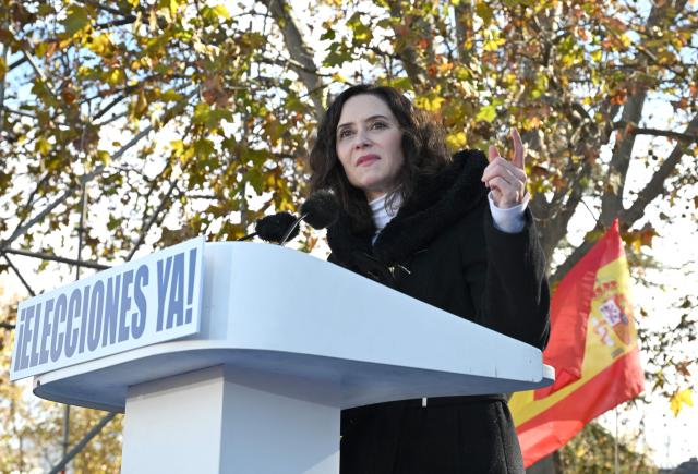 Madrid's regional president Isabel Ayuso speaks on a podium bearing the writing 'Elections now' during a demonstration against corruption called by the right-wing opposition party Partido Popular (PP) in front of Debod Temple in Madrid on November 30, 2025. (Photo by JAVIER SORIANO / AFP)