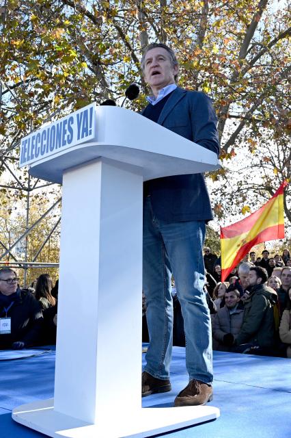 Spain's opposition right-wing Popular Party (PP) leader Alberto Nunez Feijoo speaks on a podium bearing the writing 'Elections now' during a demonstration against corruption called by the PP in front of Debod Temple in Madrid on November 30, 2025. (Photo by JAVIER SORIANO / AFP)