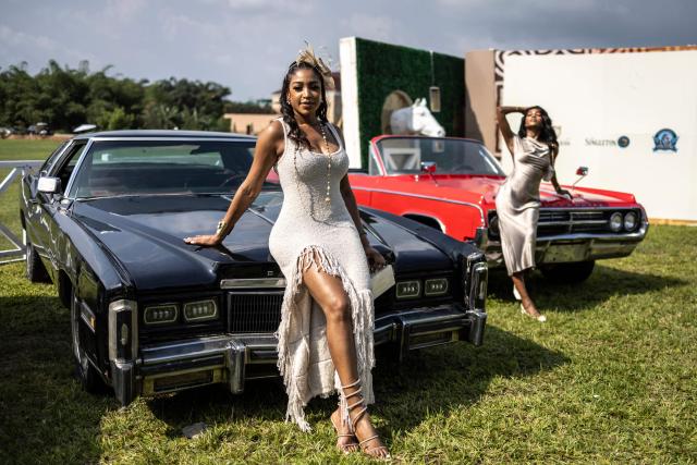 TOPSHOT - Attendees pose with classic cars exhibited during the Isimi Festival 2025 at the Isimi Wellness and Polo Country Estate in Epe, Lagos State, on November 29, 2025. (Photo by OLYMPIA DE MAISMONT / AFP)