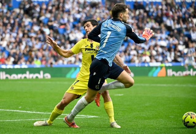Villarreal's Spanish forward #07 Gerard challenges Real Sociedad's Spanish goalkeeper #01 Alex Remiro during the Spanish league football match between Real Sociedad and Villarreal CF at Anoeta Stadium in San Sebastian on November 30, 2025. (Photo by ANDER GILLENEA / AFP)