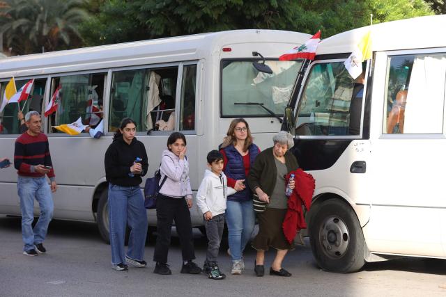 Buses transporting the faithful arrive as people wait for Pope Leo XIV in Beirut's eastern suburb of Hazmieh, where the Pope will drive past as he makes his way to the Presidential Palace on November 30, 2025. Pope Leo XIV wrapped up a four-day trip to Turkey on November 30, 2025, after a warm welcome by its tiny Christian community, before heading to Lebanon with a message of peace for the crisis-mired nation. (Photo by AFP)