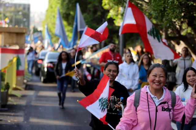 Foreigners and Lebanese wave the Lebanese flag as they wait for Pope Leo XIV in Beirut's eastern suburb of Hazmieh, where the he will drive past as he makes his way to the Presidential Palace on November 30, 2025. Pope Leo XIV wrapped up a four-day trip to Turkey on November 30, 2025, after a warm welcome by its tiny Christian community, before heading to Lebanon with a message of peace for the crisis-mired nation. (Photo by AFP)