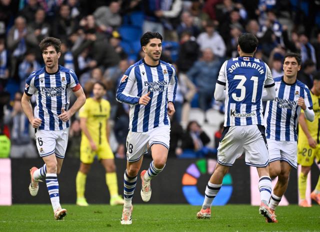Real Sociedad's Spanish defender #18 Carlos Soler (C) celebrates scoring his team's first goal during the Spanish league football match between Real Sociedad and Villarreal CF at Anoeta Stadium in San Sebastian on November 30, 2025. (Photo by ANDER GILLENEA / AFP)