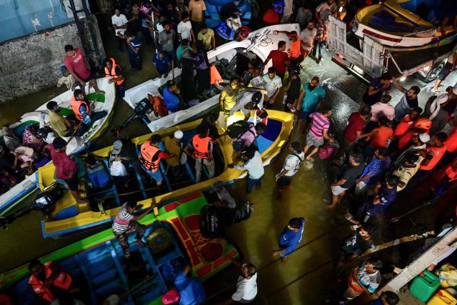 Rescue personnel evacuate people riding on boats belonging to Sri Lanka's army on a flooded street after heavy rainfall in Wellampitiya on the outskirts of Colombo on November 30, 2025. Low-lying areas of Sri Lanka's capital were flooded on November 30 after a powerful cyclone triggered heavy rains and mudslides across the island, killing at least 212 people and leaving many more missing. (Photo by Ishara S. KODIKARA / AFP)