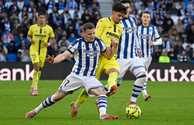 Real Sociedad's Spanish forward #17 Sergio Gomez fights for the ball with Villarreal's Moroccan forward #11 Ilias Akhomach during the Spanish league football match between Real Sociedad and Villarreal CF at Anoeta Stadium in San Sebastian on November 30, 2025. (Photo by ANDER GILLENEA / AFP)