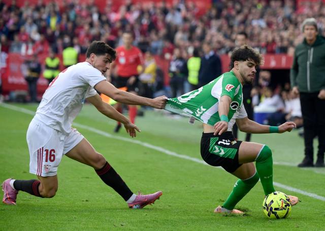 Real Betis' Moroccan forward #10 Abde Ezzalzouli fights for the ball with Sevilla's Spanish defender #16 Juanlu Sanchez the Spanish league football match between Sevilla FC and Real Betis at Ramon Sanchez Pizjuan Stadium in Seville on November 30, 2025. (Photo by CRISTINA QUICLER / AFP)