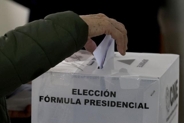 A person casts his vote at a polling station during the general election in Tegucigalpa, on November 30, 2025. Hondurans voted for president on Sunday amid threats by US President Donald Trump to cut aid to the country if his preferred candidate loses. (Photo by Lucas AGUAYO / AFP)