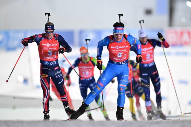 Norway's Endre Stromsheim (L) and Italy's Tommaso Giacomel compete during the mixed relay event of the IBU Biathlon World Cup in Oestersund, Sweden on November 30, 2025. (Photo by Hanna BRUNLOF / TT NEWS AGENCY / AFP) / Sweden OUT