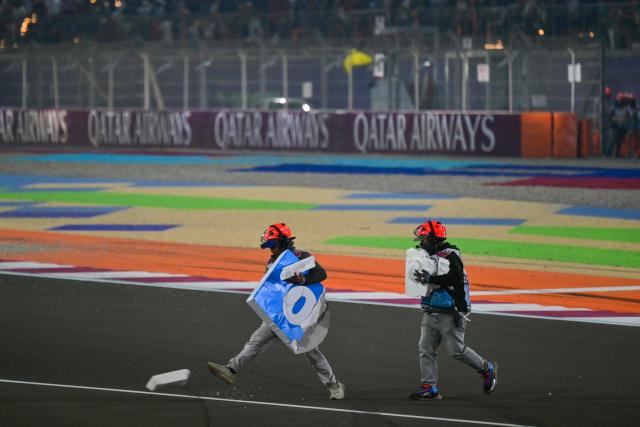Marshals clear the track from debris after a crash during the Formula One Qatar Grand Prix at the Lusail International Circuit in Lusail on November 30, 2025. (Photo by Andrej ISAKOVIC / AFP)