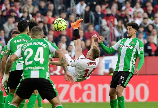 Sevilla's Spanish forward #14 Gerard Fernandez 'Peque' attempts a bicycle kick during the Spanish league football match between Sevilla FC and Real Betis at Ramon Sanchez Pizjuan Stadium in Seville on November 30, 2025. (Photo by CRISTINA QUICLER / AFP)