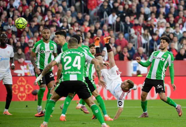 Sevilla's Spanish forward #14 Gerard Fernandez 'Peque' attempts a bicycle kick during the Spanish league football match between Sevilla FC and Real Betis at Ramon Sanchez Pizjuan Stadium in Seville on November 30, 2025. (Photo by CRISTINA QUICLER / AFP)